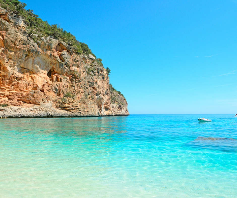 Strand mit türkisblauem Wasser an der Klippe