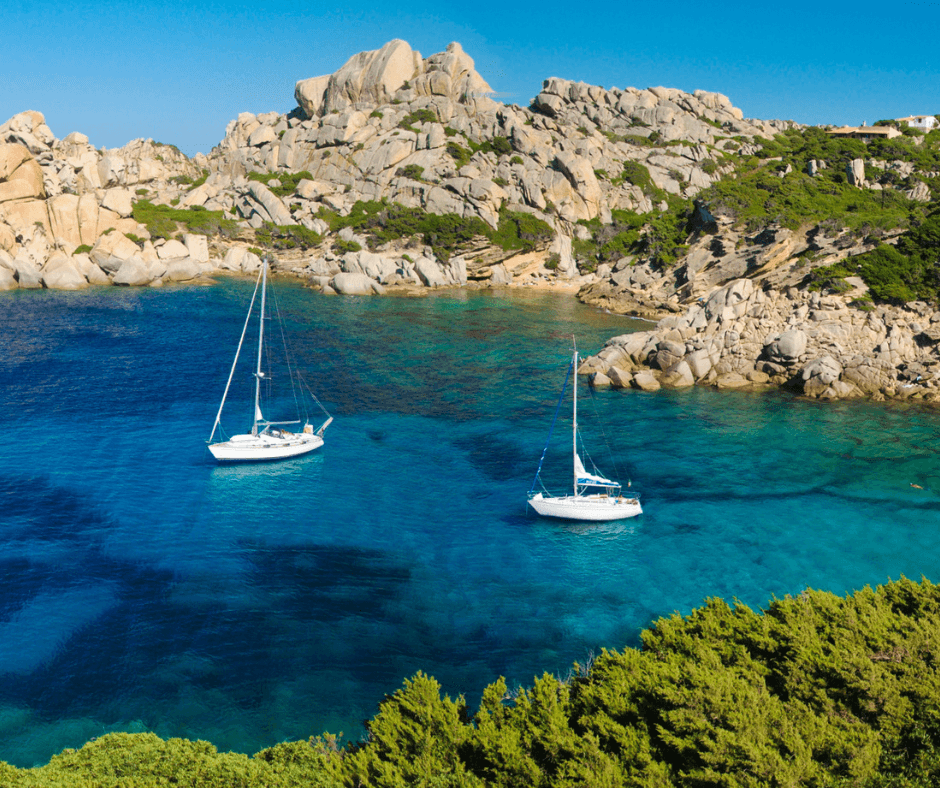 Azurblaues Wasser und Segelboote in einer Bucht von Sardinien zeigen die Vorzüge des hiesigen Segellreviers. 