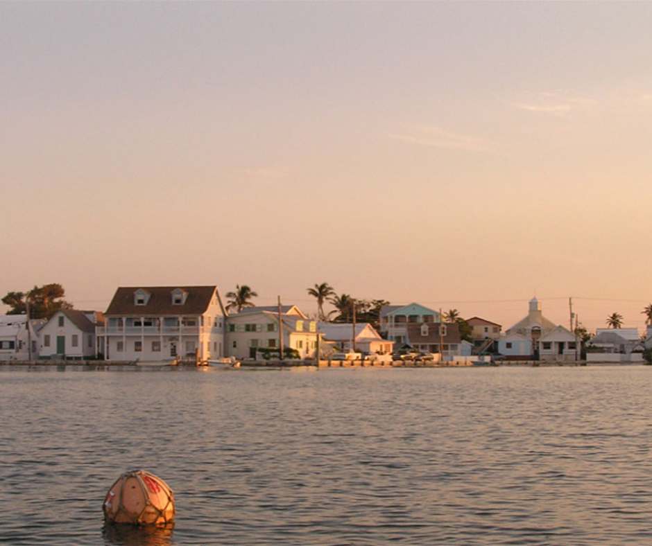 Segeltörn in den Bahamas - New Plymouth, Bunte Häuser am Wasser mit Palmen bei Sonnenuntergang 
