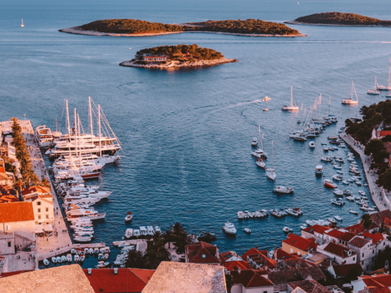 Inselhopping Kroatien - Hvar aus der Vogelperspektive, Boote am Hafen, Sonnenuntergang, historische Altstadt, üppige Inseln ragen aus dem Wasser