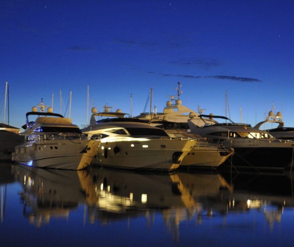 Yachthafen mit vier Yachten zu sehen. Es ist Abendstimmung.