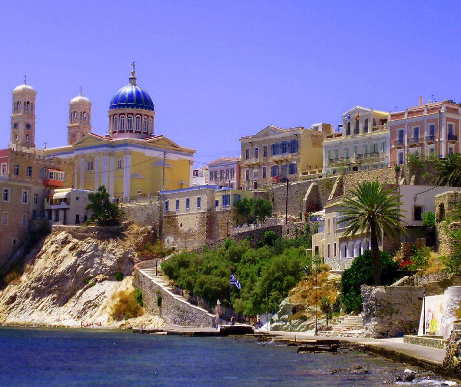 Ufer von Syros mit vielen Gebäuden und einer Treppe, die nach oben führt.