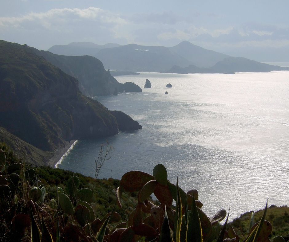Aussicht von Inseln Vulcano auf Klipppen und das Meer. Andere Insel iim Hintergrund.
