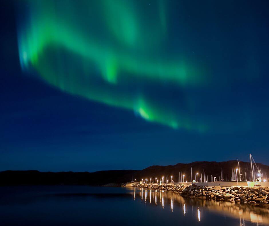 Nordlichter in Norwegen. Rechts am Rand sieht man die Promenade und Häuser.