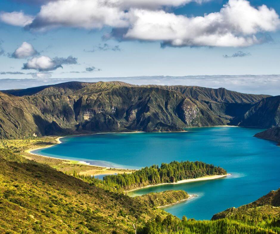 Ein Bild von den Azoren, einem guten Ort für Whale Watching in Europa. Man sieht grüne Berge und einen blauen See.