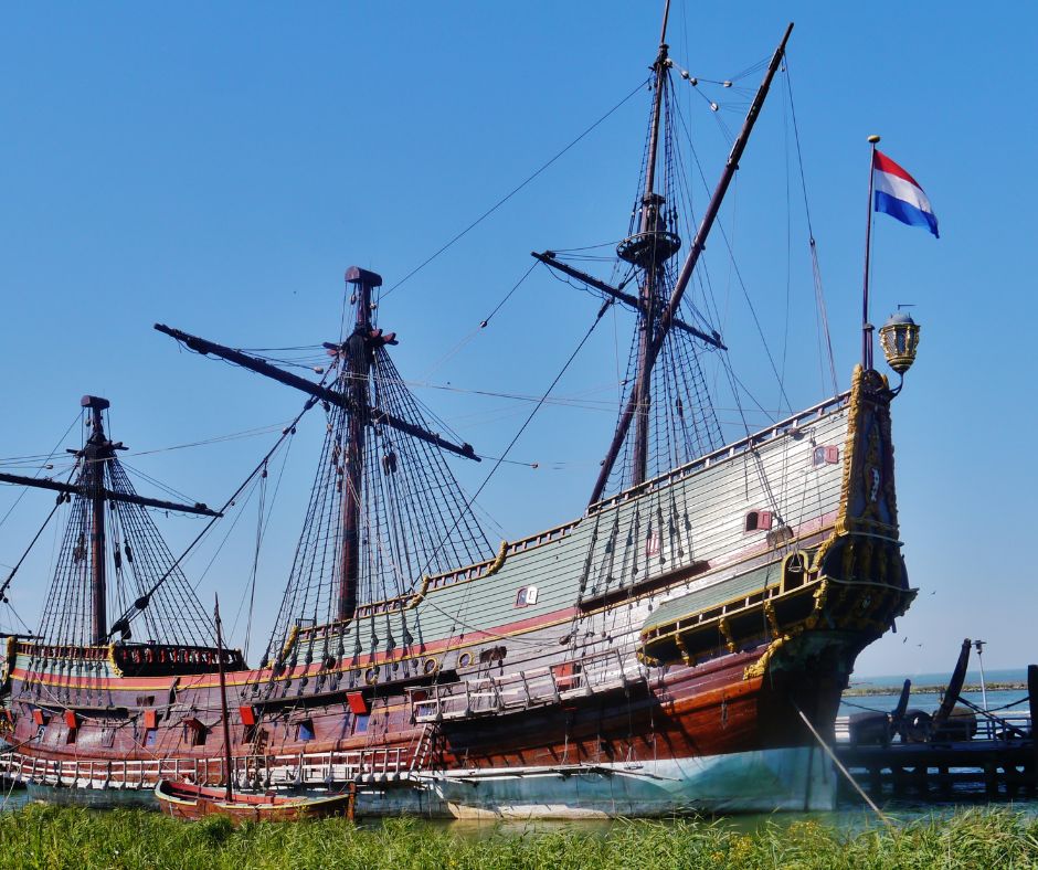 Alte Replika eines Segelschiffes in Lelystad. Dafür sieht man grünes Gras und im Hintergrund einen blauen Himmel.