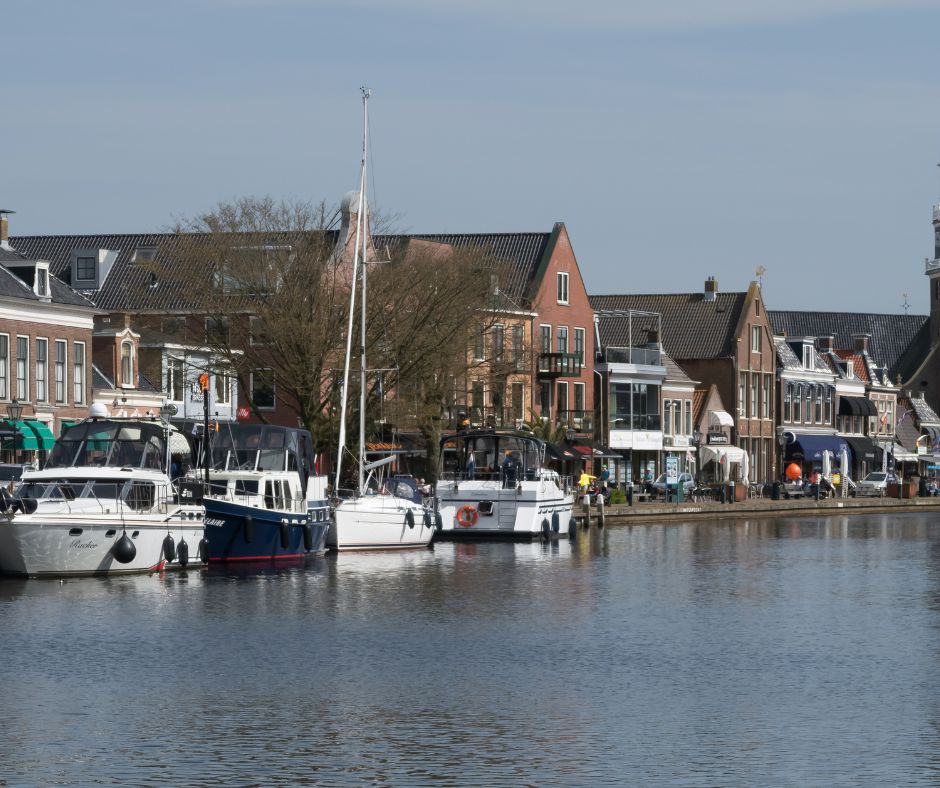 Boote auf dem Wasser. Am Ufer sieht man Häuser während Ihres Segeltörn IJsselmeer