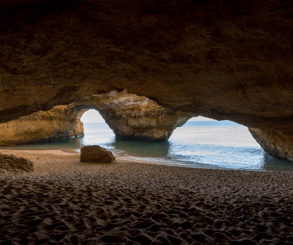 Die Höhlen von Benagil - Strand in einer Höhle mit zwei Öffnungen auf das Meer, durch die Tageslicht hereinscheint